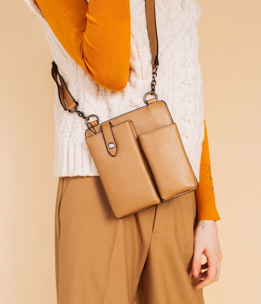Female model wearing a white vest and tan shoulder bag