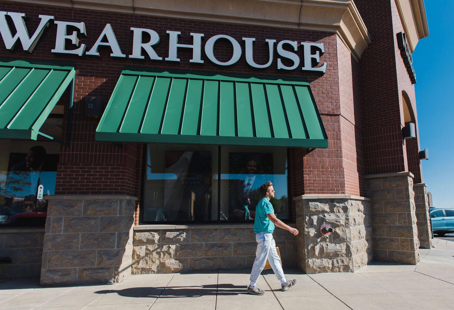 Exterior view of a man entering Men's Warehouse